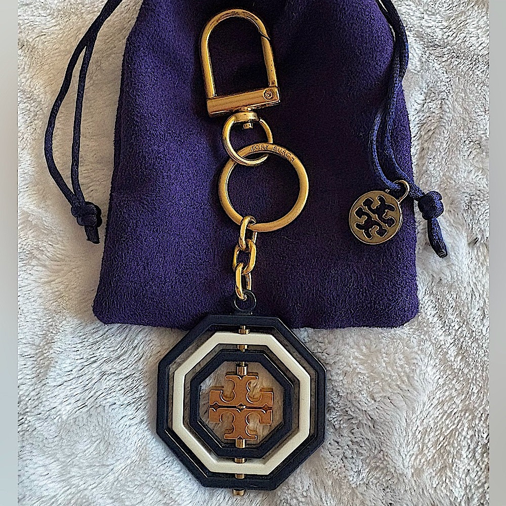 TORY BURCH:Navy Blue, White, and Gold Rotating Geo Keychain with clip closure.